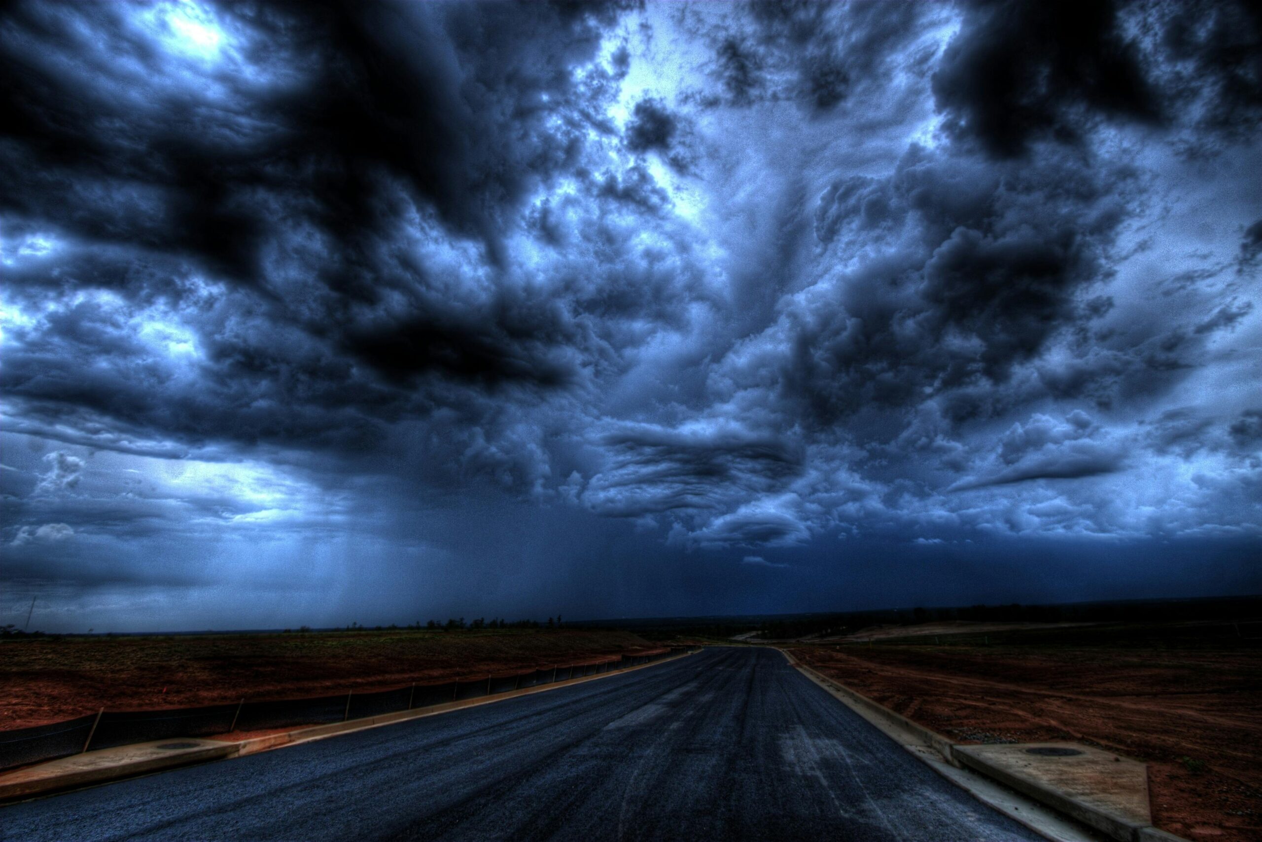 A dark road with storm clouds.